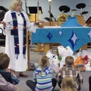 Rev. June explains the Christmas Share hamper program to the children.